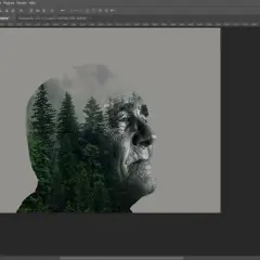 Volto anziano sovrapposto a una foresta di pini, effetto creato con lo strumento contagocce in Photoshop.
