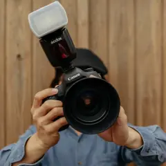 Persona con una Canon e un flash Godox, pronta a scattare.