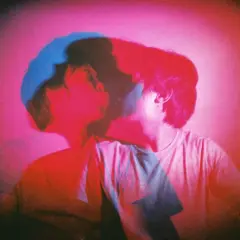 Due persone si baciano in una foto flash con luci rosa e blu.