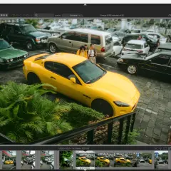 Un'auto sportiva gialla parcheggiata tra altre auto, con due persone sullo sfondo. Interfaccia di darktable, un'alternativa a Lightroom Classic senza abbonamento.