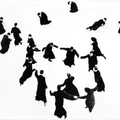 Mario Giacomelli: pretini in cerchio, alcuni in ginocchio, altri in piedi, in un gioco di ombre e forme.