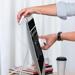 Mani che interagiscono con un dispositivo bianco su uno schermo, il colore foto è predominante.