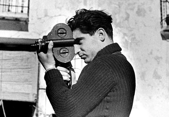 Giovane uomo con cinepresa, forse il fotografo più famoso del suo tempo, cattura un momento.
