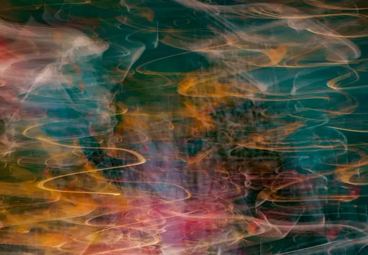 Vortici di luce dorata e rosa danzano su uno sfondo verde acqua profondo, creando immagini surreali che evocano un sogno etereo.