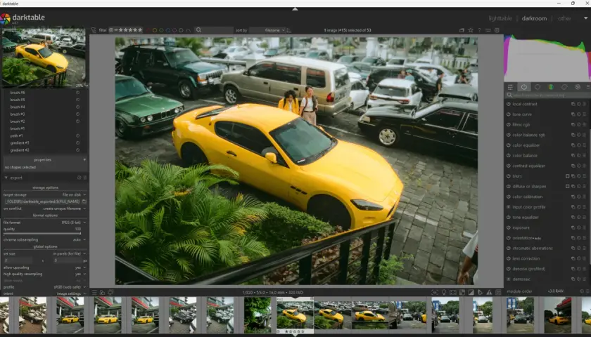 Un'auto sportiva gialla parcheggiata tra altre auto, con due persone sullo sfondo. Interfaccia di darktable, un'alternativa a Lightroom Classic senza abbonamento.