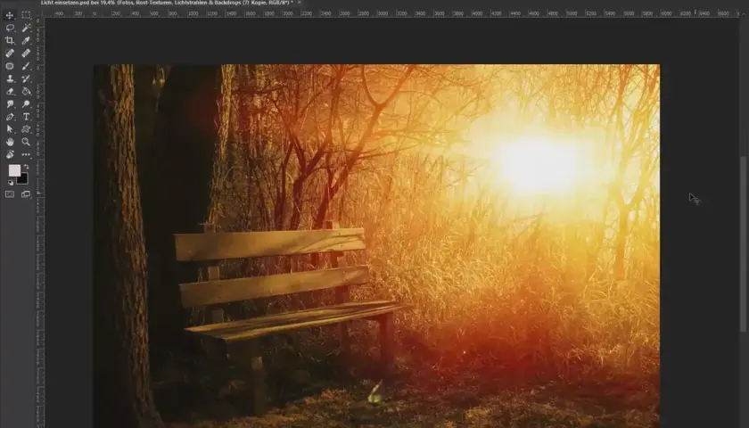 Panchina in un bosco al tramonto, con raggi di luce dorata che filtrano tra gli alberi. Un'atmosfera magica, quasi da inserire texture Photoshop.