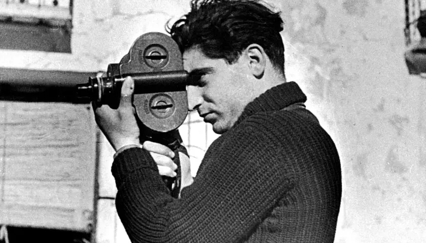 Giovane uomo con cinepresa, forse il fotografo più famoso del suo tempo, cattura un momento.