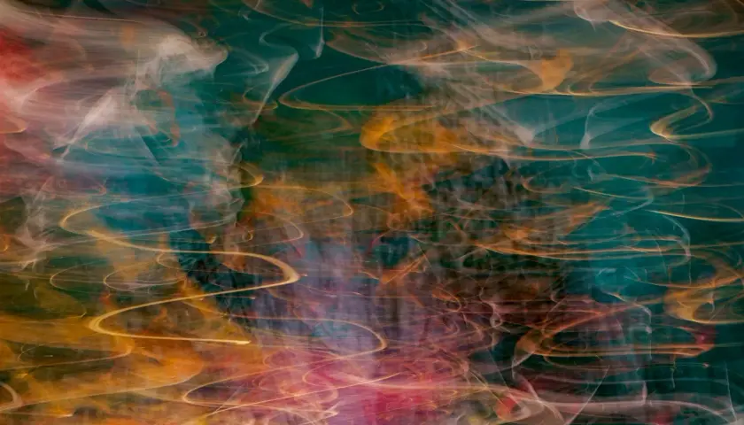Vortici di luce dorata e rosa danzano su uno sfondo verde acqua profondo, creando immagini surreali che evocano un sogno etereo.