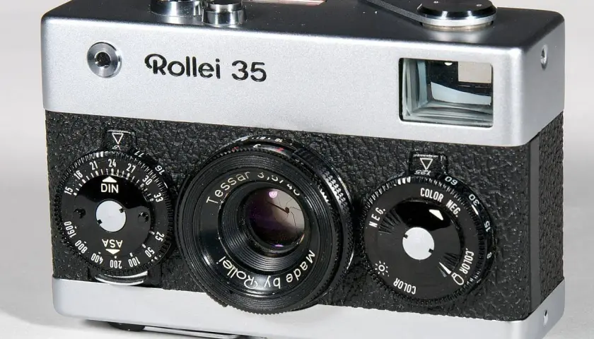A silver and black Rollei 35 camera with a Tessar lens and multiple dials.