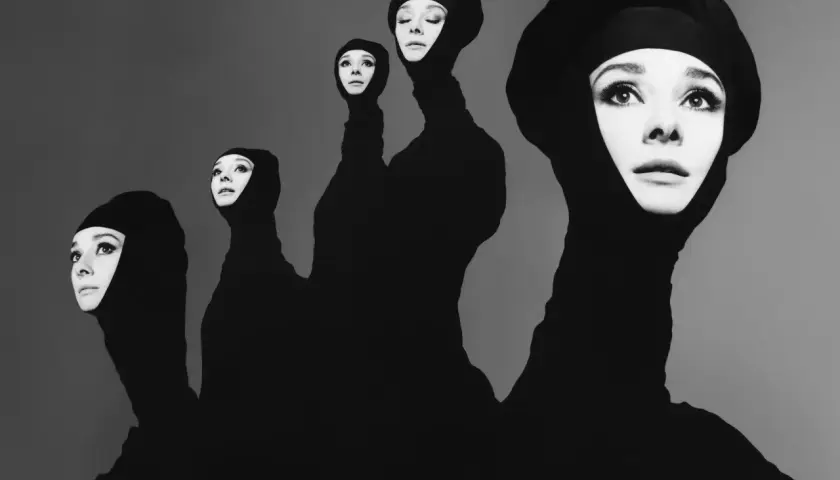 Cinque volti di Audrey Hepburn emergono da un tessuto nero, un'iconica opera del fotografo Avedon.