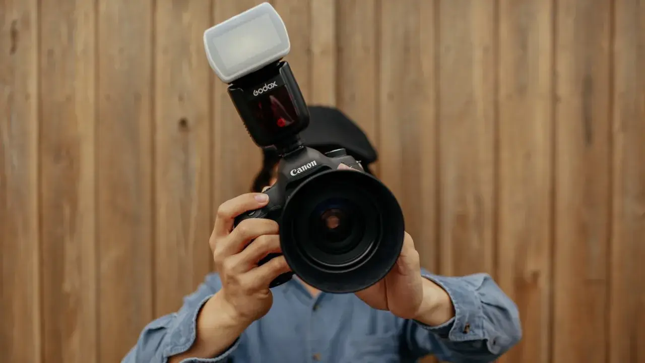 Persona con una Canon e un flash Godox, pronta a scattare.