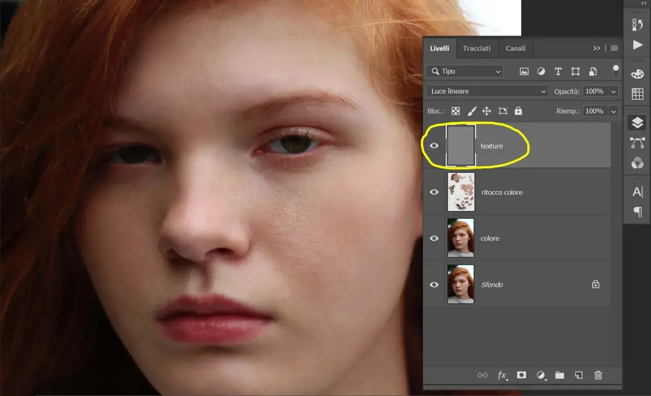 Primo piano di una ragazza con capelli rossi, con pannello livelli Photoshop aperto. Livello "texture" evidenziato, per un ritocco pelle photoshop.
