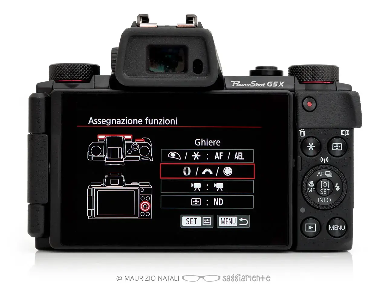 Retro della Canon PowerShot G5X con menu "Assegnazione funzioni" attivo, che mostra le opzioni per le ghiere.