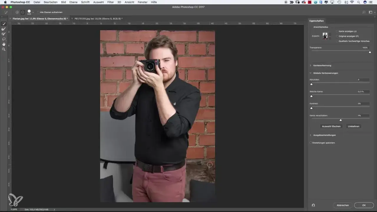 Uomo con fotocamera in mano, sullo sfondo un muro di mattoni. Interfaccia di Photoshop aperta, con pannello "Proprietà" visibile, utile per la selezione rapida Photoshop.