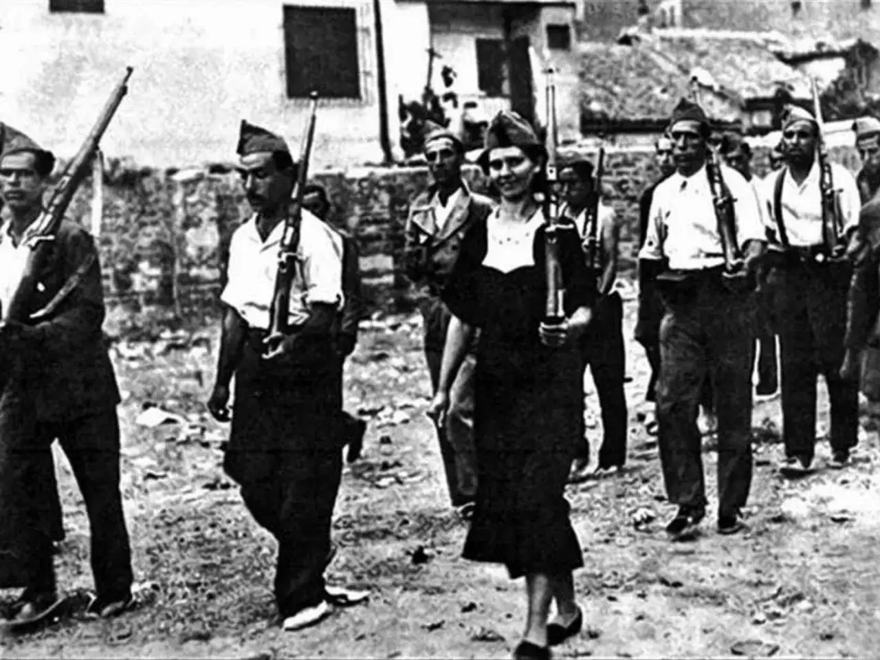 Miliziani in marcia, tra cui una donna sorridente, ricordano la coraggiosa Gerda Taro, la cui morte segnò un'epoca.