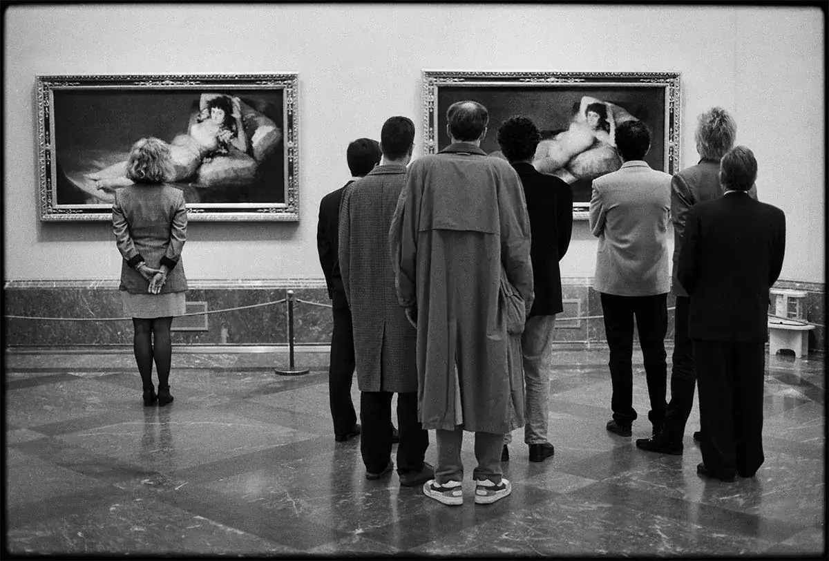 Elliot fotografo cattura un gruppo di persone che ammirano due dipinti in una galleria d'arte.
