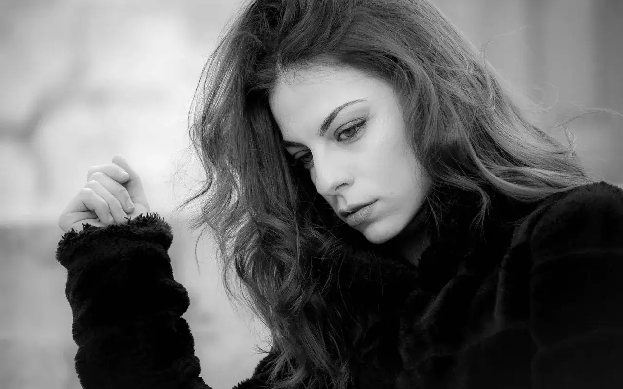 Un volto pensieroso in un ritratto in bianco e nero. Le sue emozioni sono catturate in queste bellissime fotografie, un'istantanea di un momento intimo.